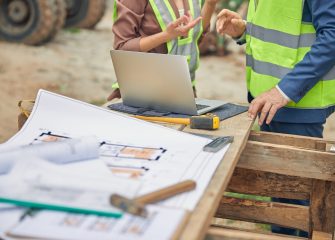 Cropped photo of a young Caucasian female engineer talking to a senior male worker outside